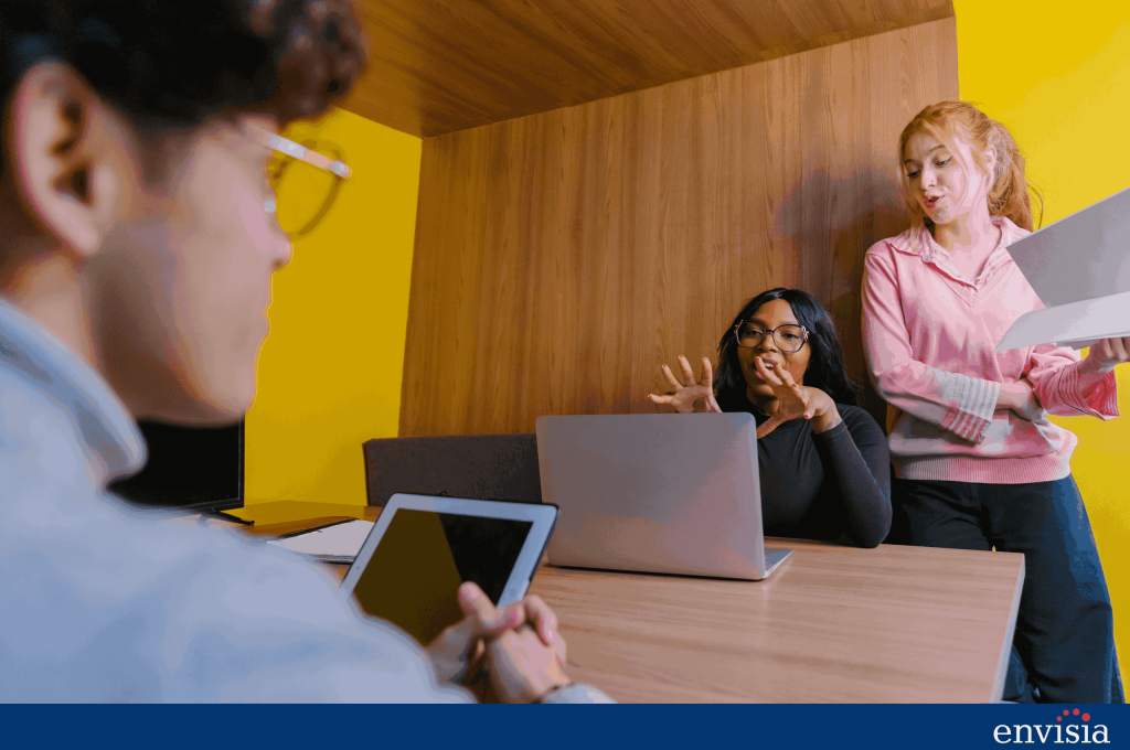 Group of professionals discussing and collaborating during a meeting, representing teamwork and communication skills developed through executive coaching.