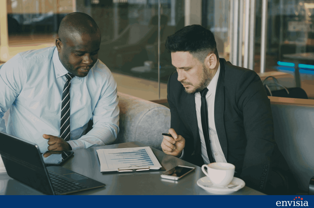 Manager and employee discussing a development report on a clipboard during a coaching conversation