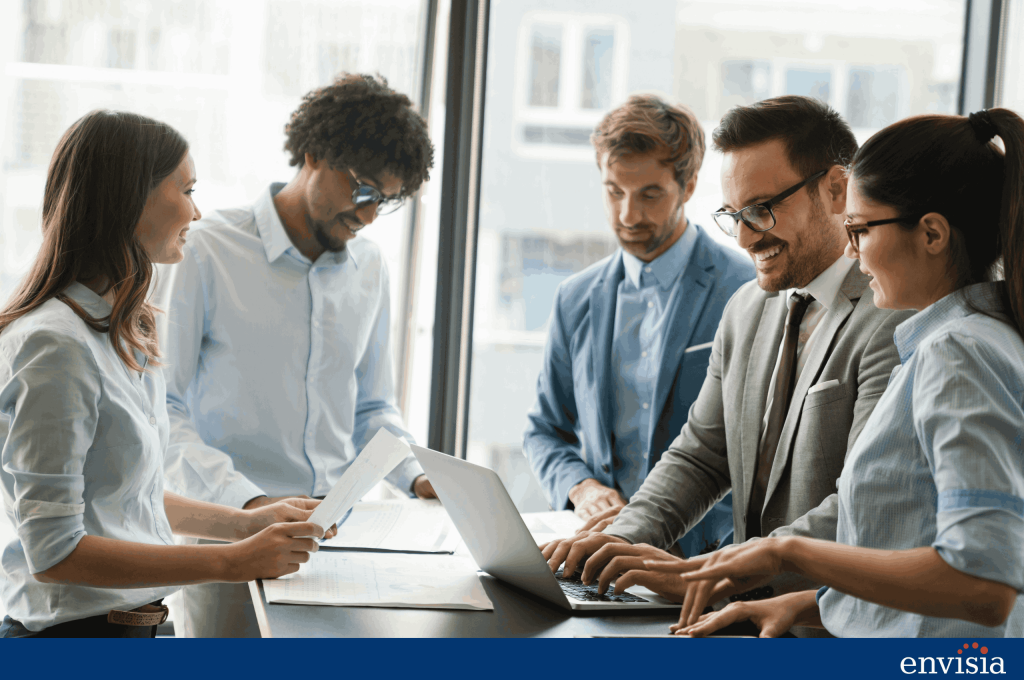 Group of colleagues reviewing feedback results together on a laptop in a modern workplace