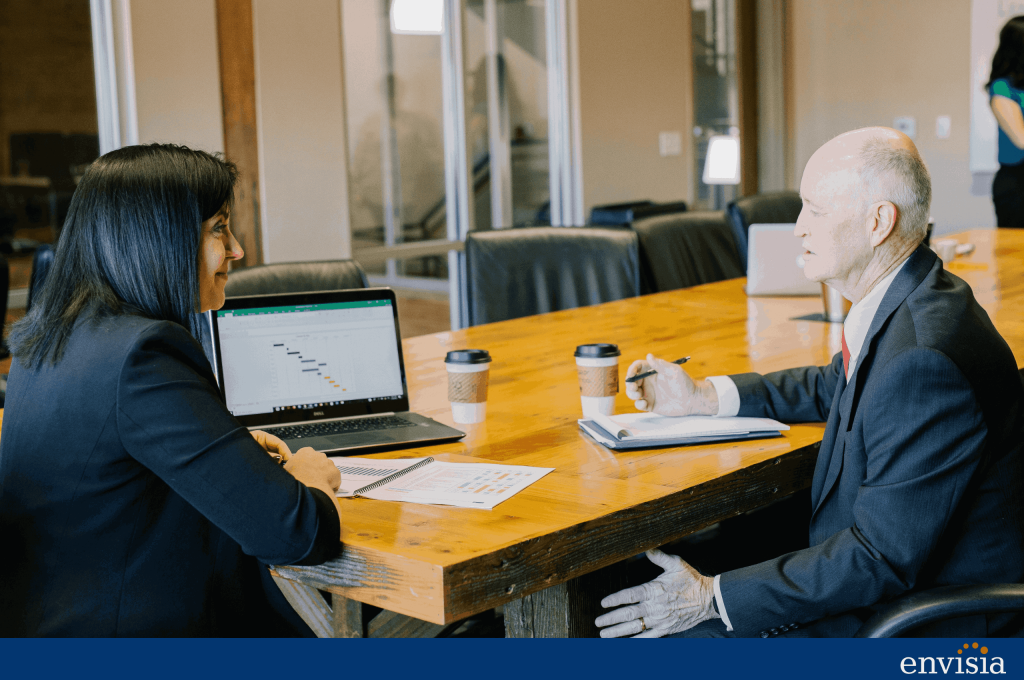 Manager and employee discussing a 360 degree feedback report together in a meeting room as part of a development plan